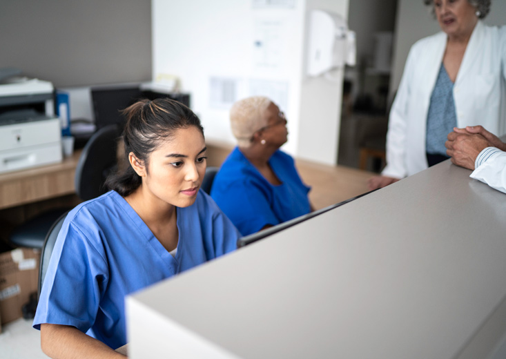 Nurse looking at charts at nursing station