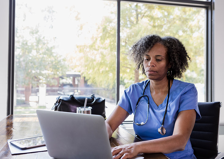 nurse typing on laptop